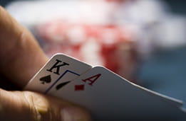 Et sæt blackjackkort der bliver løftet let op af en spiller.